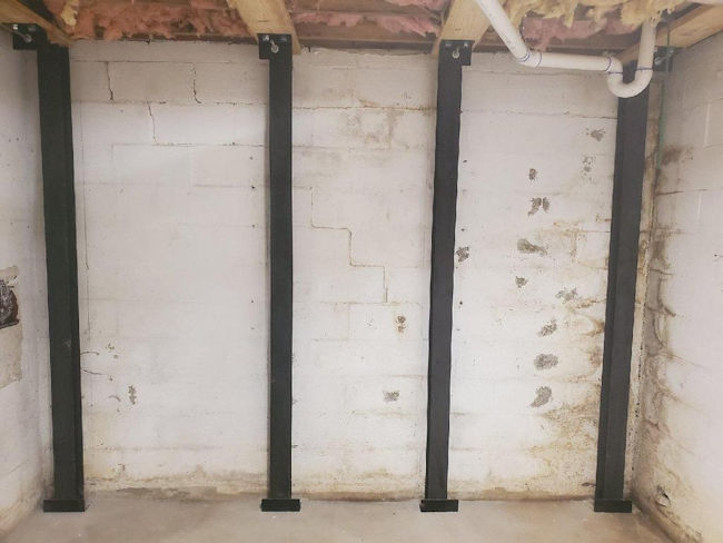 Steel force beams to stabilize a basement wall that was leaning under soil pressure on a home in the Upstate of South Carolina.