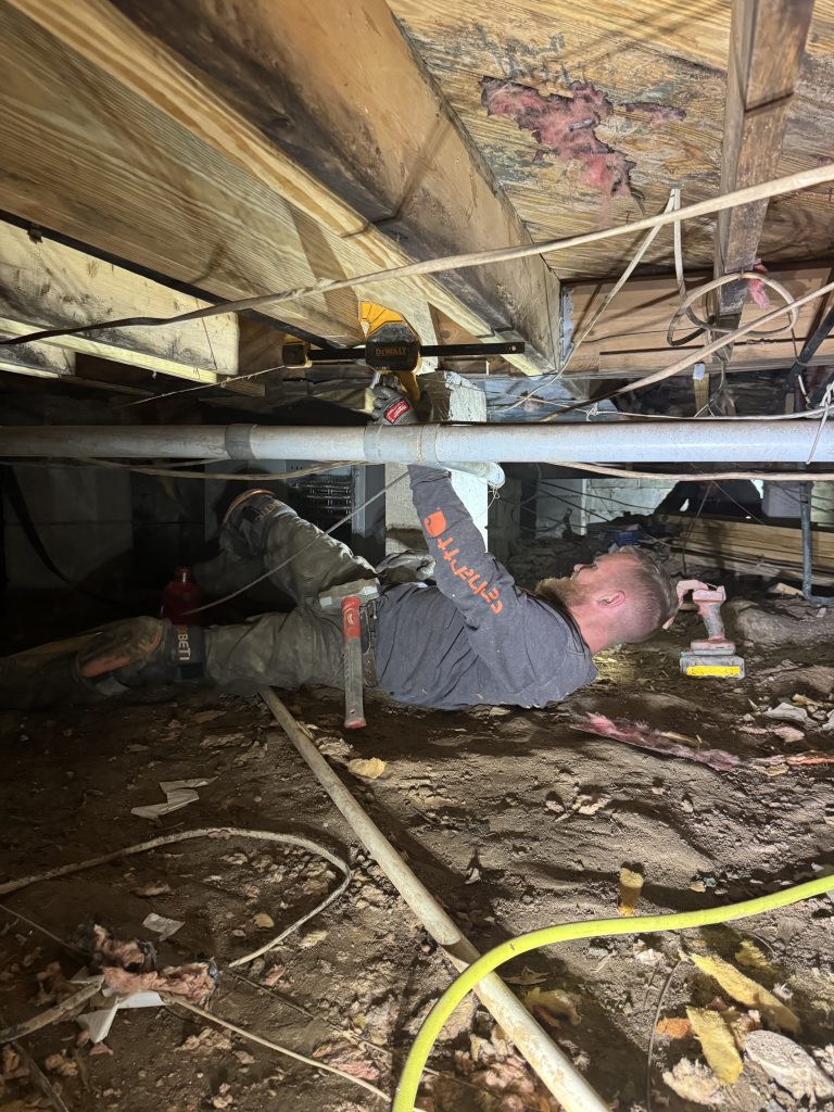 A USR technician sistering a damaged floor joist in a upstate crawlspace.