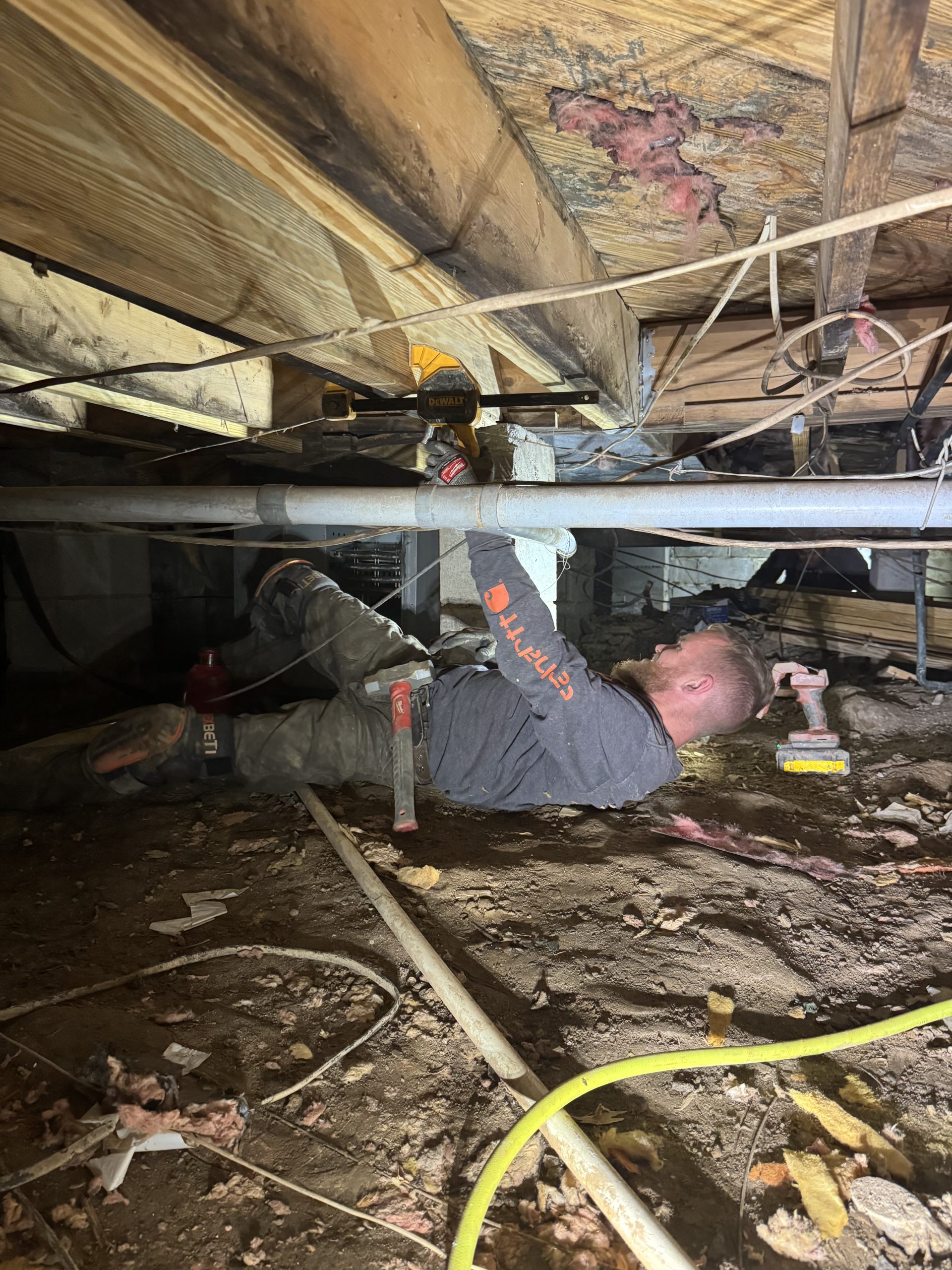 A USR technician sistering a damaged floor joist in a upstate crawlspace.