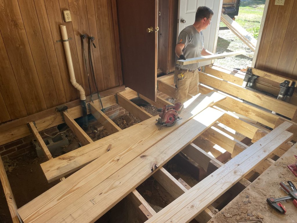 loading lumber into the room for a whole flooring system termite damage repair in the Upstate of South Carolina