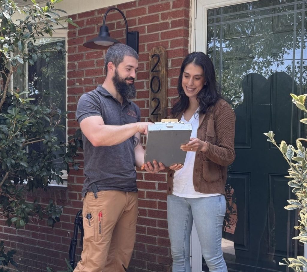 a happy customer reviewing an estimate with USR on their front porch.
