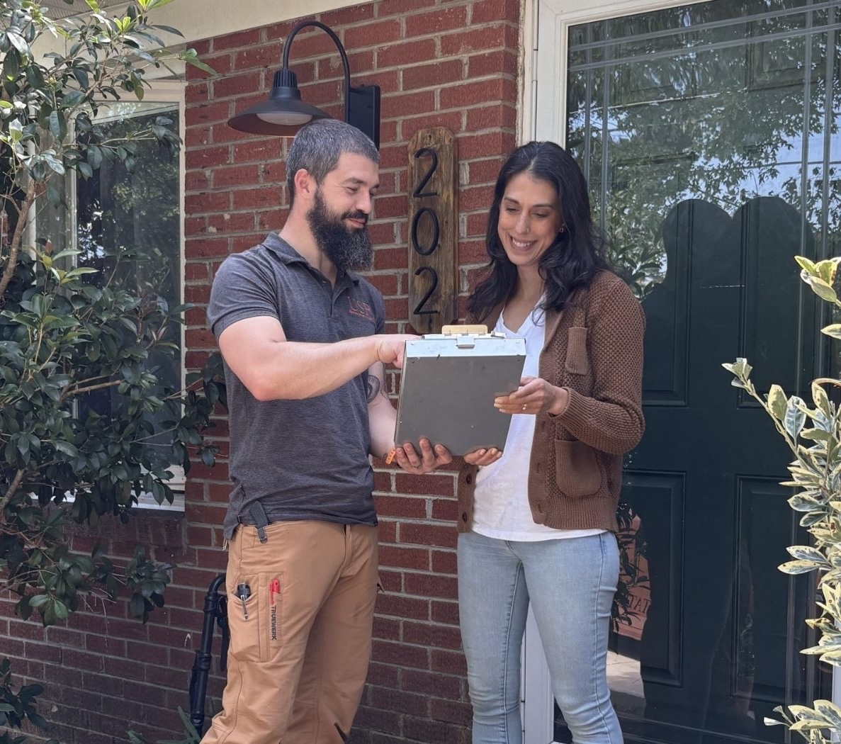 a happy customer reviewing an estimate with USR on their front porch.